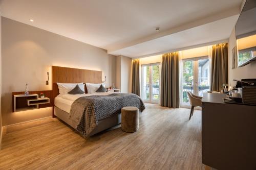 een hotelkamer met een bed en een bureau bij MAXIMILIAN MUNICH Apartments & Hotel in München