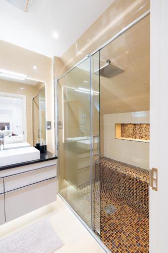 a glass shower in a bathroom with a sink at Granite cottage in Isle of Jersey