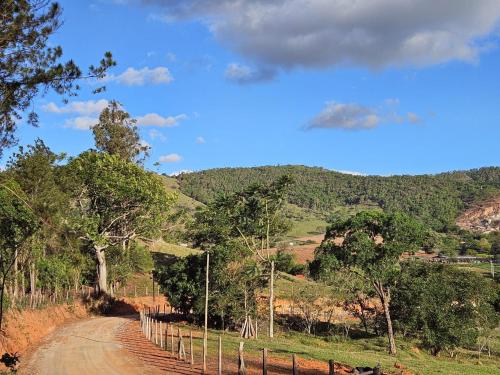 a dirt road with a fence on the side of a hill at Recanto felicidade casa de vovó in Monte Sião