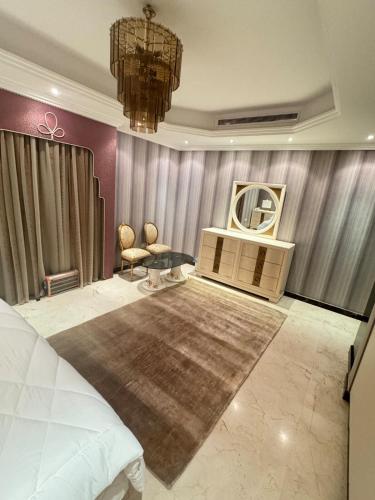 a bedroom with a bed and a table and a stage at Alzahra Jaccuzi apt in Quai