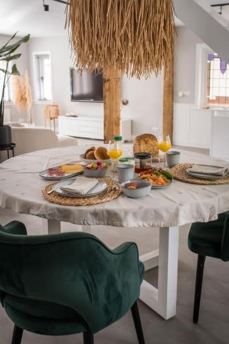 een witte tafel met eten en drinken erop bij Tovve Loft in Schagen