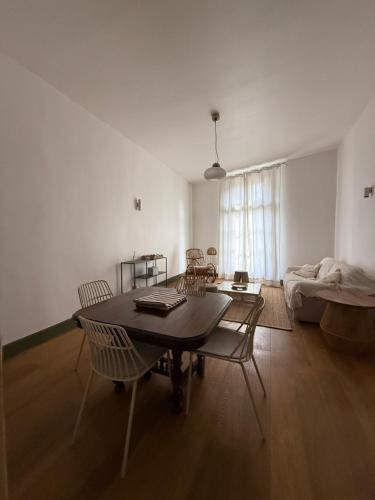 ein Wohnzimmer mit Tisch und Stühlen und einer Couch in der Unterkunft appartement lumineux cosy 4 couchages coeur de narbonne in Narbonne