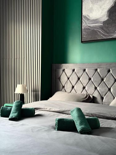a bedroom with a large bed with green walls at D&D Emerald House Anfield in Liverpool