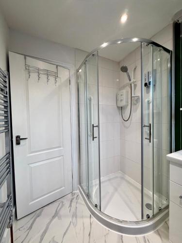 a shower with a glass door in a bathroom at D&D Emerald House Anfield in Liverpool