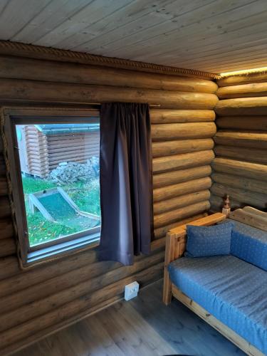 a bedroom with a window in a log cabin at Gäststuga och bastu in Oravais