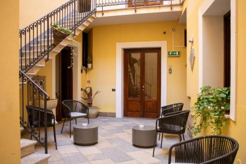 a patio with chairs and a wooden door and stairs at San Domenico Residence by BADIA NUOVA in Trapani