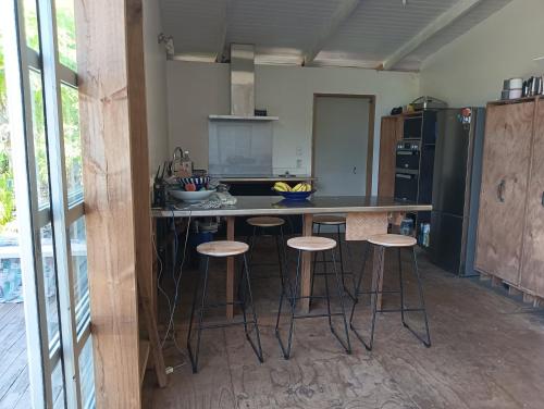 a kitchen with a island with bar stools in it at Mountain Breeze Rarotonga in Arorangi