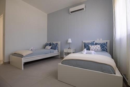 苏莎亚Sosua Ocean Village Villa 24的一间带两张床和一扇窗户的白色卧室