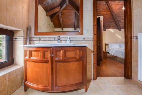 a bathroom with a sink and a bedroom at Chalet Panorama -Three Level Escape in Parnassos in Arachova
