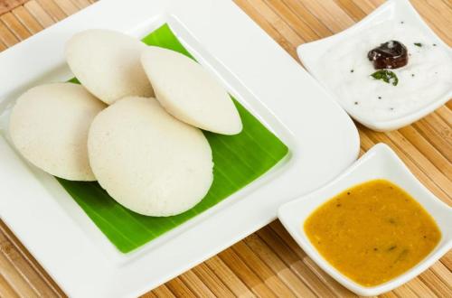 Un plato de comida con manzanas y salsa para mojar. en Hotel SVA, en Sitam Petta