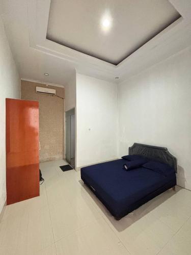 a bedroom with a blue bed in a room at Pondok Agung Rubicon in Yogyakarta