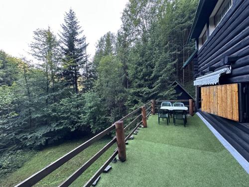 a balcony of a house with a table and chairs at Srub pod Lysou horou in Ostravice