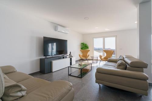 Una sala de estar con un sofá y un televisor de pantalla plana. en Villa Lotus Peralta with sea view, en Lourinhã