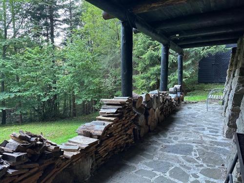 a stack of logs next to a stone wall at Srub pod Lysou horou in Ostravice
