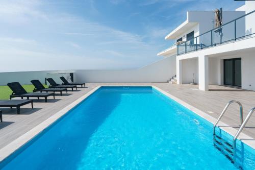 una piscina frente a una villa en Villa Lotus Peralta with sea view, en Lourinhã
