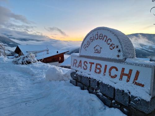 a sign for a restaurant in the snow at Residence Rastbichl - Apartments & Indoor-Pool in Maranza