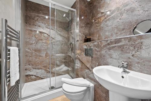a bathroom with a sink toilet and a shower at Stylish & Spacious 3BR 3Bath with Private Parking, WiFi, Smart TVs in Spon End