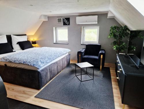 a bedroom with a bed and a tv and a chair at Studio del Pueblo in Bechtsrieth