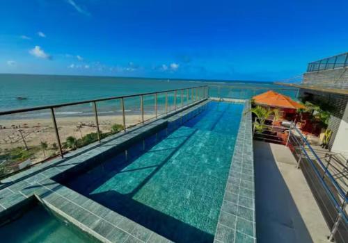 a swimming pool with a view of the beach at Flat com vista linda para o mar! in Cabedelo