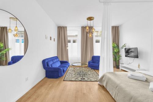 - une chambre avec 2 chaises bleues et un miroir dans l'établissement Trendy Apartments in Centrum, à Staré Mesto
