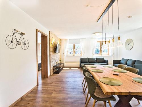 a dining room and living room with a wooden table at Ferienwohnung Hochkalterblick in Schönau am Königssee