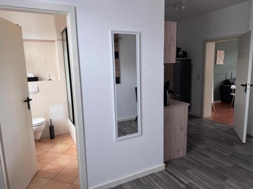 a bathroom with a toilet and a mirror on a wall at Moderne Wohnung Bitterfeld in Bitterfeld