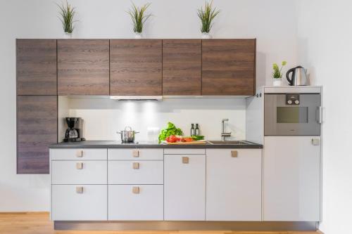 a kitchen with white cabinets and a sink at Watzmann Panorama in Berchtesgaden