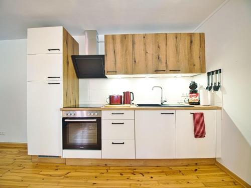 a kitchen with white appliances and wooden cabinets at Ferienwohnung Faes in Berchtesgaden