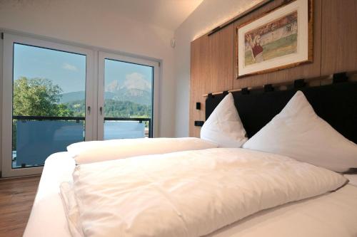 1 dormitorio con 2 camas blancas y ventana grande en Rottenhöfer Retreat Penthouse, en Berchtesgaden