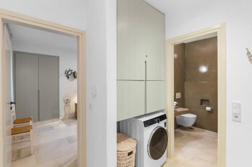 a bathroom with a washing machine and a toilet at Villa Zaneta with swimming pool in Prodromos Paros