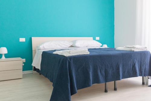 a blue bedroom with a bed with a blue wall at B&B Via Nazionale in Milazzo