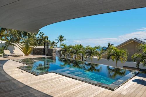 a swimming pool on the roof of a house at SUMMER VIEW classée 5 étoiles - Magnifique Villa 10 personnes avec piscine miroir chauffée à 29 degrés, bain à remous intégré et vue mer idéalement située Chemin Summer - ST GILLES LES BAINS in Saint-Gilles les Bains