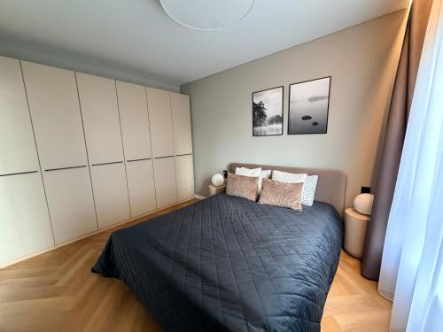 a bedroom with a bed with a black blanket at Two bedroom LUXURIOUS Spacios Apartment in Vilnius