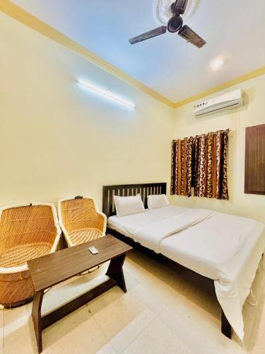 a bedroom with a bed and a table and a ceiling fan at Rv stay pushkar in Pushkar
