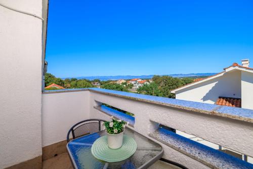 un piccolo tavolo con una pianta sul balcone di Apartment Dragica a Malinska