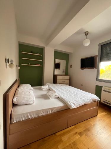 sypialnia z dużym łóżkiem z zielonym zagłówkiem w obiekcie Skopje&Joy Central Flat w mieście Skopje
