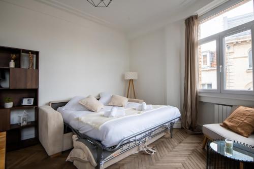 a white bedroom with a bed and a window at Magnifique appartement proche gare et centre ville in Lille