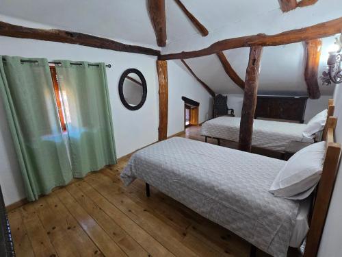 a bedroom with two beds and a mirror in a room at Casa La Fuencisla in Castiltierra