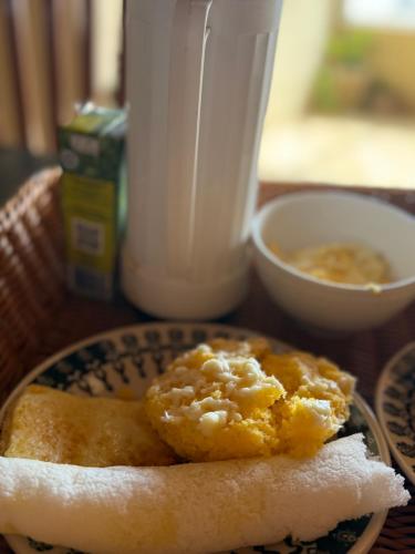 a plate of food on a table with a drink at Bangalô Encantador Praia da Baleia in Itapipoca
