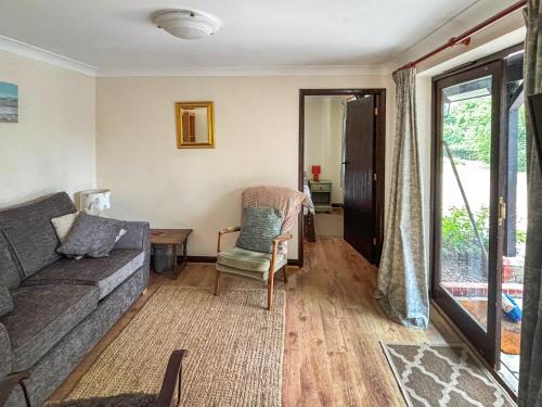 a living room with a couch and a chair at Fuschia Chalet in Framlingham