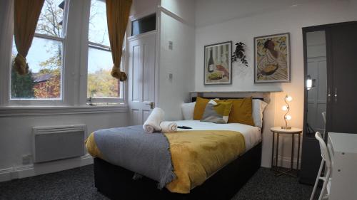 a bedroom with a bed and two windows at Charming Studio in the heart of birmingham in Birmingham