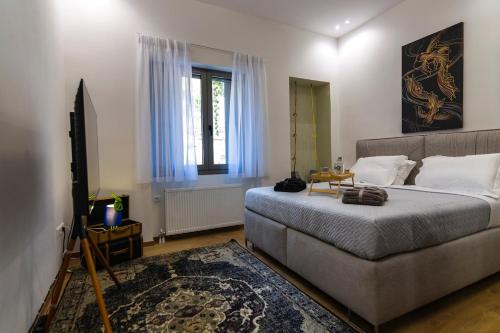a bedroom with a bed and a couch and a window at Timeless 1 bedroom Luxury at Panathenaic Stadium in Mesochórion