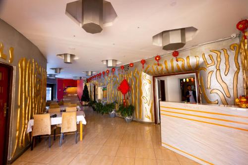 a restaurant with a counter and tables and chairs at Jade Inn in Arusha