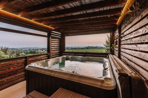 a bath tub in a room with a large window at Villa Di Sotto in Castelnuovo Berardenga
