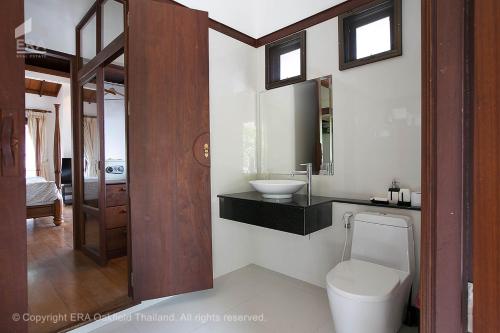 un baño con inodoro y lavabo en Villa i Mae Phim med privat pool och havsutsikt, en Mae Pim