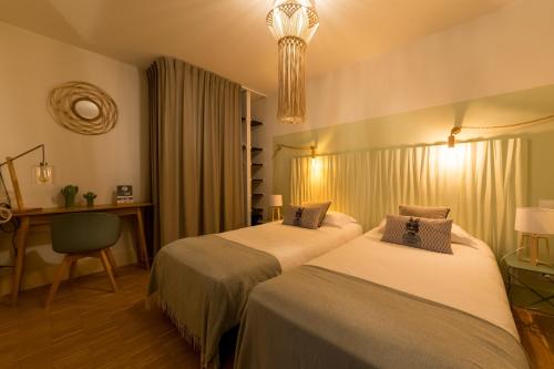 une chambre d'hôtel avec deux lits et une chaise dans l'établissement Appart Hotel Eugenie, à Louhans
