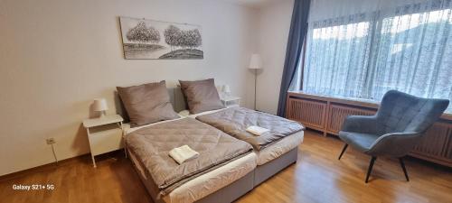 een kleine slaapkamer met een bed en een blauwe stoel bij Casaba Suite 2-150qm-4 Rooms-Free Private Parking-House with garden in Hannover