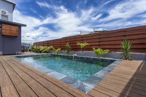 a swimming pool on the deck of a house at VILLA BELLEVUE classée 5 Etoiles - 4 chambres - piscine chauffée proche de l'aéroport et du centre de St Denis in Sainte-Marie