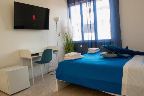 a bedroom with a bed and a desk and a television at DA MARIA'S rooms in Lido di Ostia