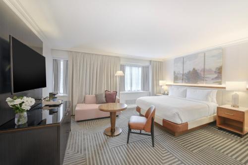 a hotel room with a bed and a flat screen tv at Capital Hilton in Washington, D.C.